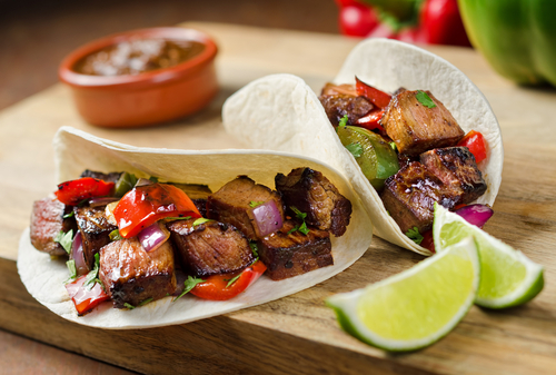 Review - Is Mr Tortilla 1 Carb Tortilla Keto Friendly? 6 keto fajitas, ready to eat, served on a wooden plate, lime and beans on the side