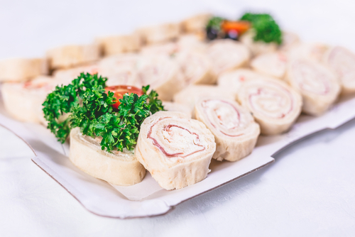 Review - Is Mr Tortilla 1 Carb Tortilla Keto Friendly? 2 keto turkey, bacon and cheese pinwheels, served on a white plate, with parsley on top