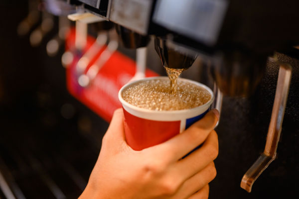 A front view of a plastic cup filled with various drinks at a fast food restaurant.
