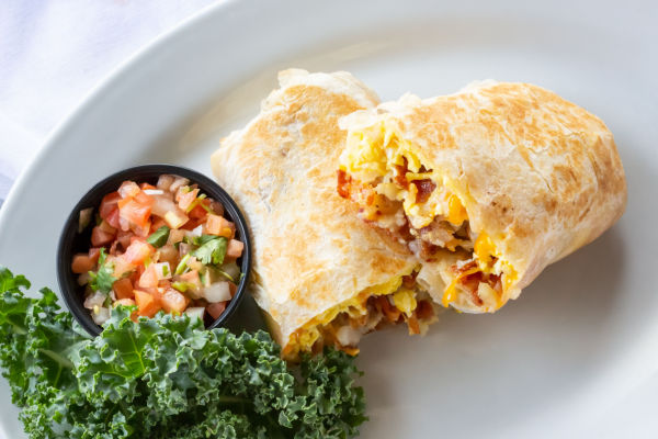 A top-down view of a burrito filled with bacon, cheese, and eggs.