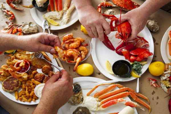 How to Make Bloves Sauce at Home: Recipe and Step-by-Step Instructions 2 Group of people enjoying a seafood feast, with crab, shrimp, and lobster on the table.