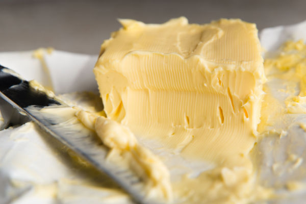 A photo of butter being sliced.