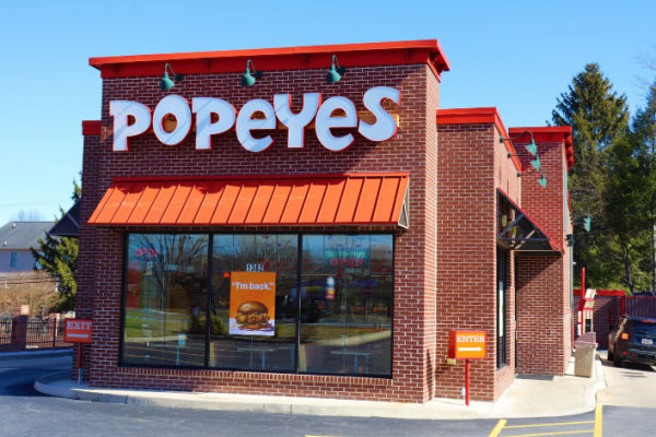 Photo of the front entrance of a Popeyes fast food restaurant.