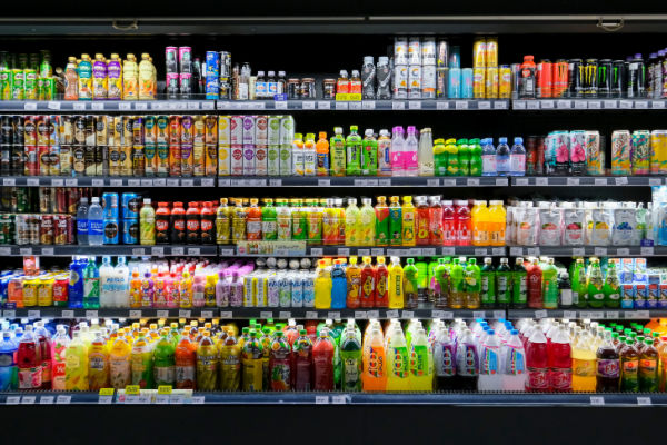 A photo of a grocery store display featuring a variety of beverages, such as bottled water, soda, juice, tea, and sports drinks.