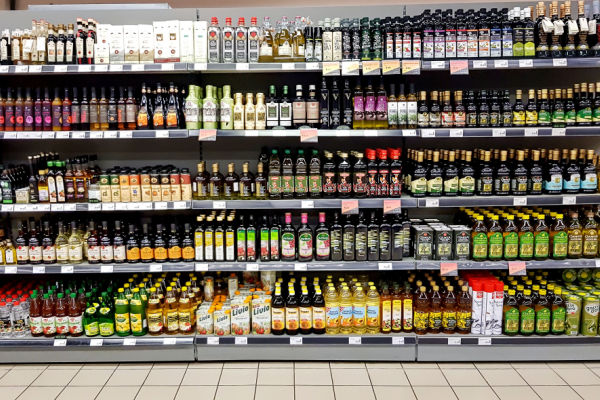 A photo of a grocery store display featuring a variety of condiments and dressings, such as ketchup, mustard, mayonnaise, barbecue sauce, salad dressing, and hot sauce.
