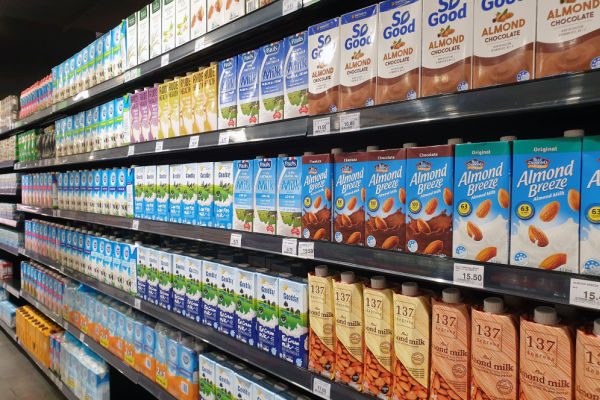 A photo of a grocery store display featuring cartons of milk, arranged on shelves or in refrigerated cases.