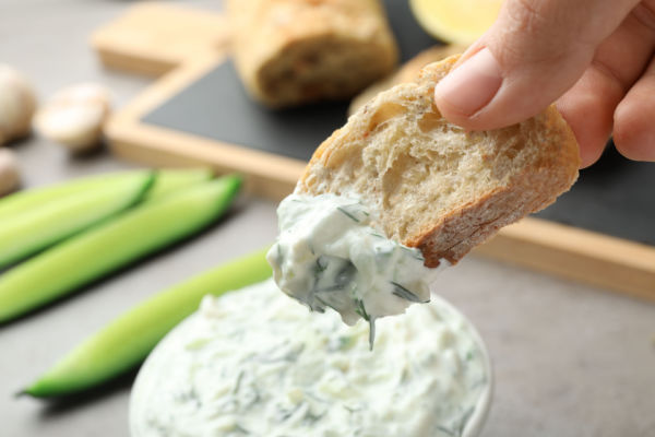 Dipped bread chip to a cucumber crab dip.
