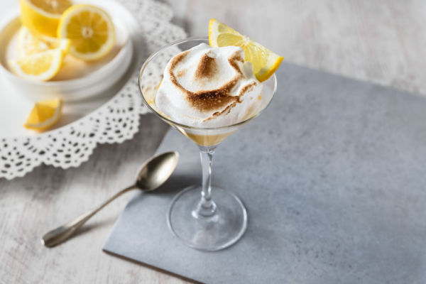 A sophisticated glass filled with an exquisite lemon dessert.  