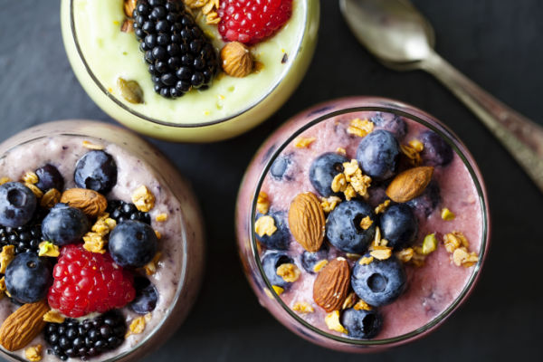 Keto Smoothie King Hacks: How to Customize Low-Carb Drink 8 A captivating top-view photo featuring a collection of smoothies in glasses, beautifully garnished with an assortment of luscious berries and crunchy nuts on top.