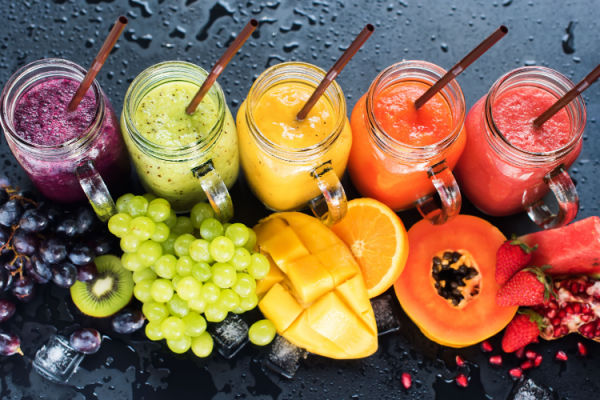 Keto Smoothie King Hacks: How to Customize Low-Carb Drink 3 An assortment of colorful fruit smoothies in various glasses, showcasing the vibrant colors of grapes, mango, orange, papaya, and strawberry.