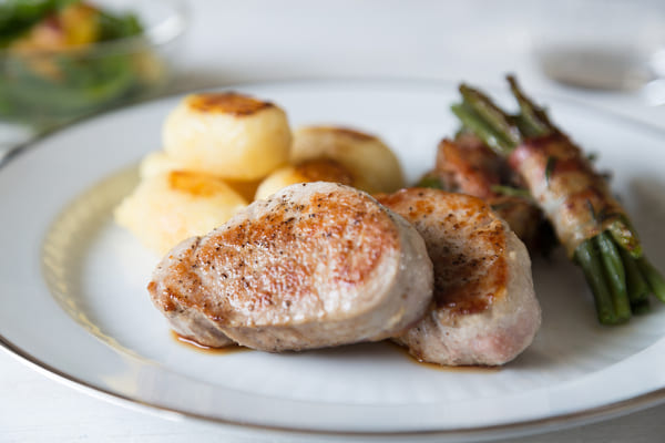 Discover the Perfect Pork Medallions for a Flavorful Feast 8 Pork medallions served with baked potatoes and bacon-wrapped green beans