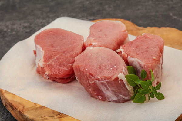 Discover the Perfect Pork Medallions for a Flavorful Feast 3 Raw pork tenderloin medallions on a wooden board