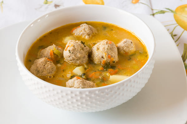 A bowl of vegetable soup with turkey meatballs