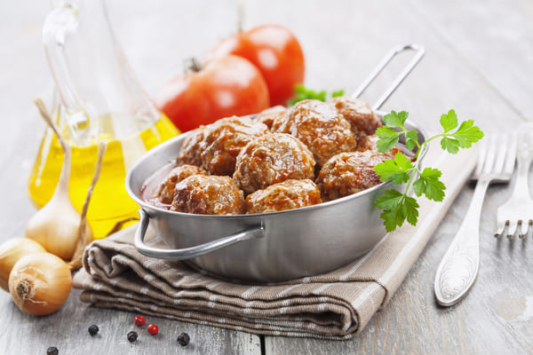 Homemade meatballs in tomato sauce with onions and herbs