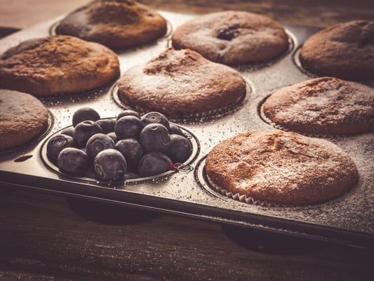 Delicious muffins bursting with juicy mixed berries, including strawberries, blueberries, and raspberries.