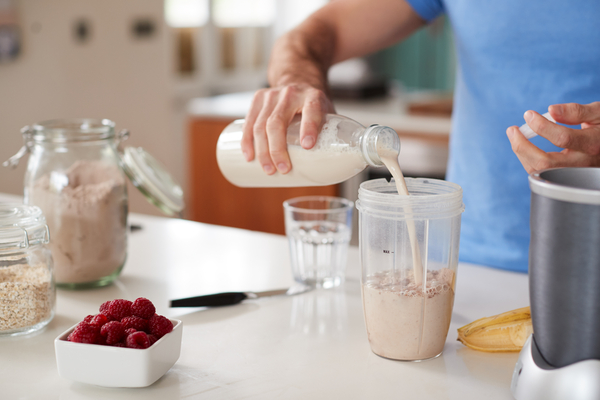 Is Shakeology Keto Friendly? A Comprehensive Guide 5 A photo capturing the act of pouring a protein shake, with the liquid streaming smoothly into a glass.