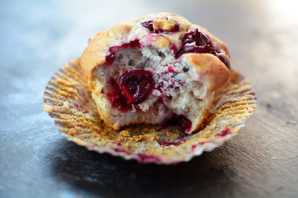 Beautiful cherry muffins with a golden-brown crust, topped with juicy red cherries, enticingly fresh and delicious.