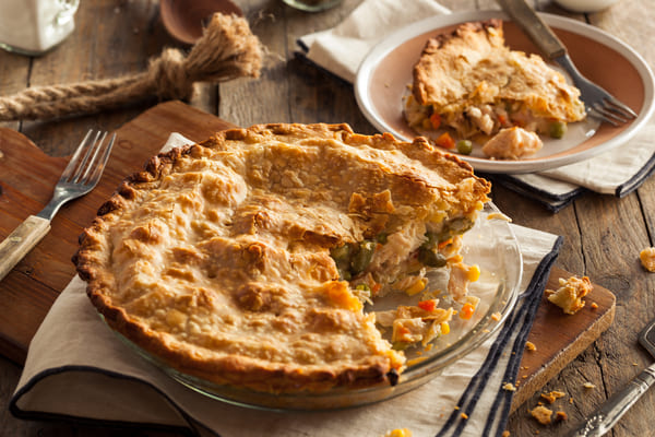 A close-up photo revealing a slice of keto chicken pot pie with a crispy golden crust, showcasing the delicious layers of filling inside