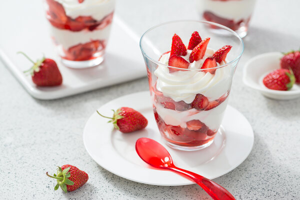 Whipped cream with strawberries in glasses