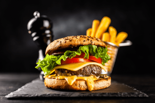 A photo of a burger accompanied by a side of golden-brown fries, presenting a classic and satisfying meal.