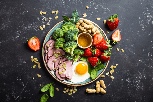 A plate containing a balanced assortment of healthy fats, protein-rich foods, and nuts.
