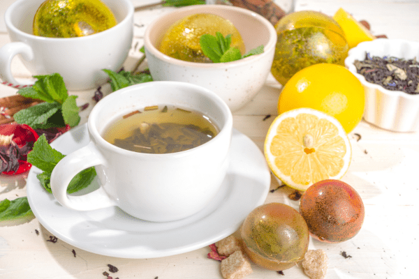 A cup of tea with a tea bomb that has melted into the hot liquid, infusing flavor.