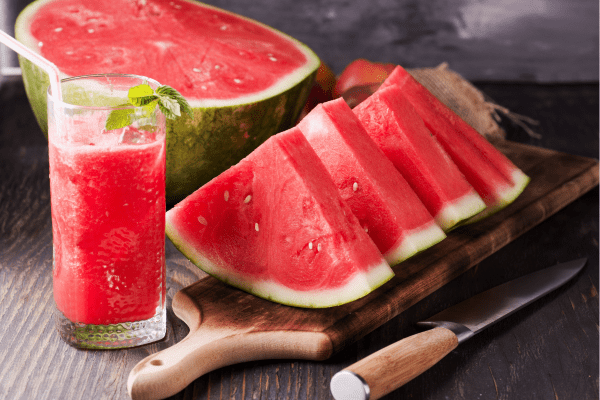 Is Watermelon Keto? Understanding the Carb Content 5 Slices of luscious watermelon arranged beautifully, accompanied by a glass filled with refreshing watermelon juice.