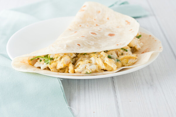 Scrambled eggs with cream cheese and herbs inside a tortilla wrap