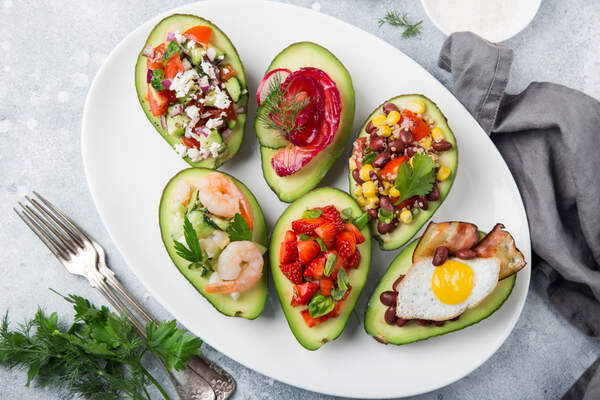 Avocado halves stuffed with different fillings
