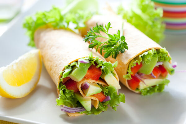 Egg white wraps filled with vegetables with a side of lemon