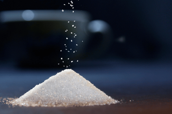 A pile of sugar granules, showcasing its fine texture and crystalline structure.