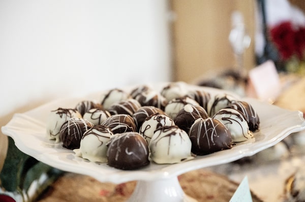 Chocolate-covered black and white fat bombs served on a plain white plate