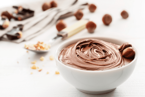 Sugar Free Nutella: Satisfy Your Sweet Tooth Guilt Free 8 A white bowl filled with luscious chocolate hazelnut spread, showcasing this beloved sweet treat's creamy and indulgent texture.
