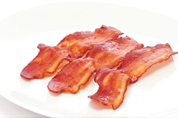 Is Bacon Bad for You? Sorting Myth from Reality 2 Crisp-cooked bacon strips on a plate representing an image on whether is bacon bad for you