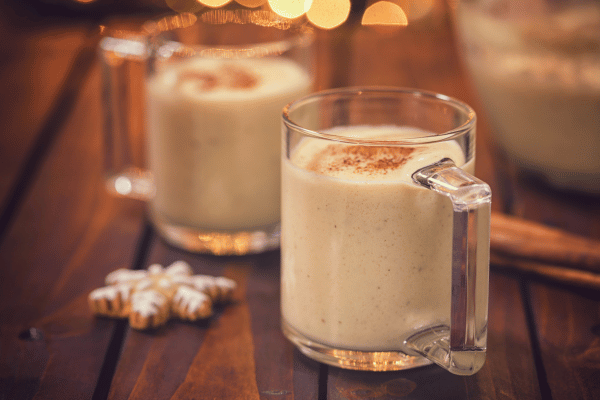 Keto Eggnog 101: A Complete Recipe Guide for the Holidays 5 Creamy mugs of eggnog, offering a rich and indulgent holiday treat in a cozy and festive setting.