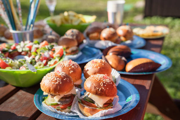 Keto Cook Out Delights: Irresistible Recipes for Your Feast 12 Salad, mini burgers, and chips on a table outside