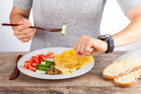 How Many Calories Break a Fast? Uncover the Ultimate Truth 2 Concept photo for intermittent fasting: a person checking the time to have a first meal after fasting