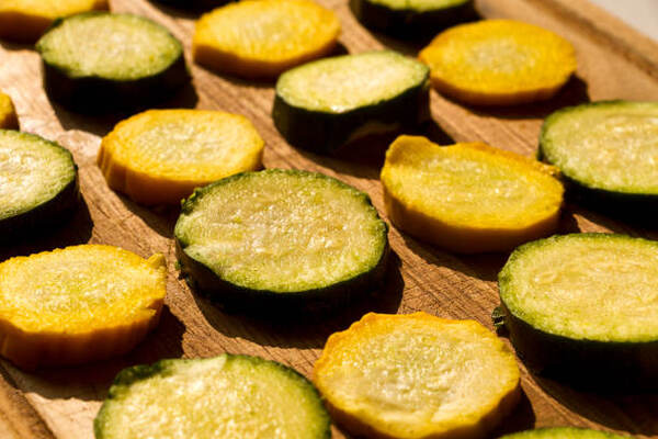 Keto Squash Casserole Recipe: A Low-Carb Delight for Dinner 5 Yellow squash slices on a wooden board