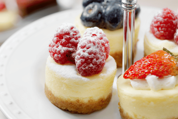 Keto Cheesecake Bites: Mini cheesecake bites elegantly presented on a three-tiered dessert stand, showcasing delightful and bite-sized portions of creamy cheesecake for a decadent treat.