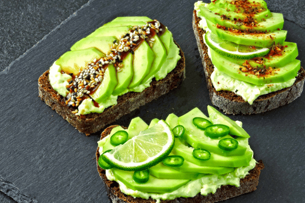 Foods that Burn Fat While You Sleep: Revitalize Your Night 4 Foods that Burn Fat While You Sleep: Healthy avocado toast with delicious-looking toppings. Keto diet. Keto snack.