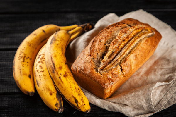 Low Carb Banana Bread: A Guide to a Homemade Goodness 5 Homemade Low Carb Banana Bread with ripe bananas on the side.