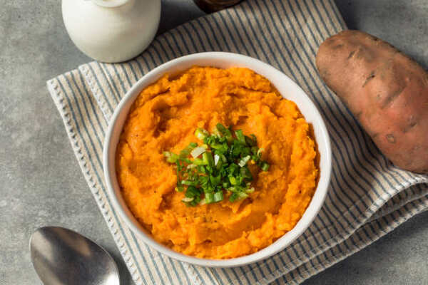 Skillet Sweet Potatoes: A Guide to Mouthwatering Perfection 4 A bowl of creamy mashed sweet potatoes with chopped green onions