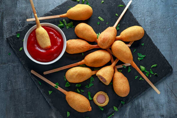 Air Fryer Corn Dogs Delight: Crispy Goodness in Every Bite! 5 Fried mini corn dogs on stick with ketchup dip