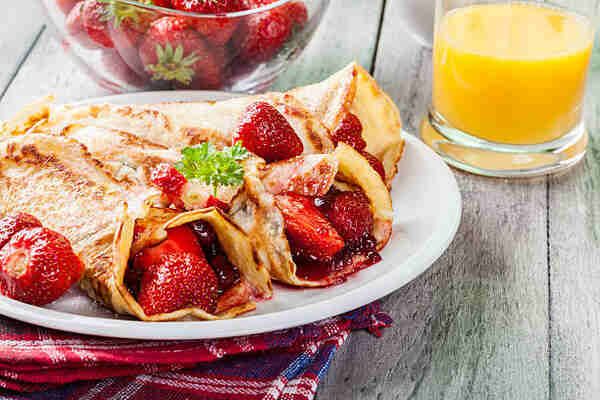 Japanese Crepes: A Mouthwatering Recipe You Can't Miss! 3 Folded strawberry crepes with strawberry sauce