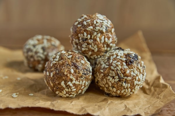 Keto Energy Balls: Energize Your Day With Amazing Recipes! 2 Energy balls covered in sesame seeds and placed on a parchment paper