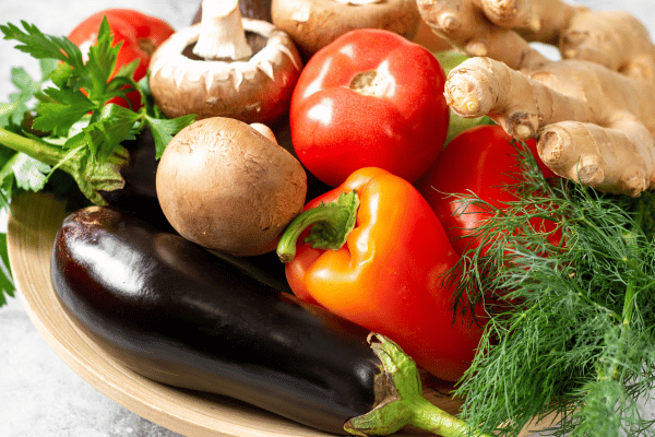 Enhance health & shed pounds with Fasting Mimicking Diet (FMD) foods: a blend of veggies, nuts, herbs, seeds, & mushrooms against a light gray backdrop.