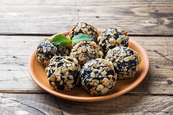 Keto Energy Balls: Energize Your Day With Amazing Recipes! 5 Energy balls covered in rolled oats, served on a brown plate