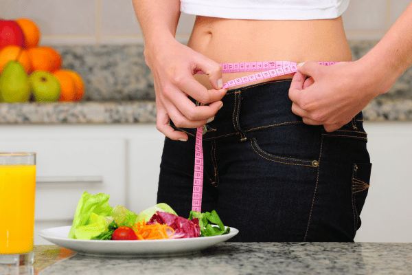 Woman with salad and measuring tape.