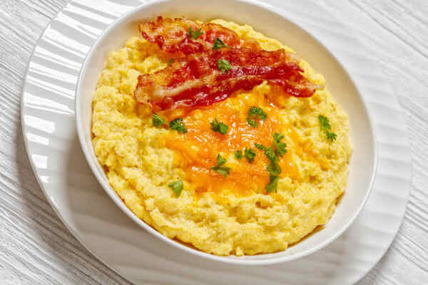 Can You Eat Grits on Keto? Unveiling Tasty Low-Carb Secrets 5 Can you eat grits on keto? A bowl of cheesy grits with bacon slices.