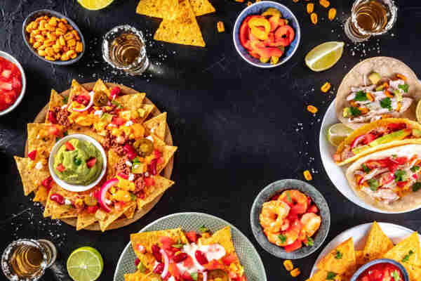 Keto Nachos Recipe: Crunchy Low-Carb Bliss in Every Bite 8 A spread of Mexican food including nachos, tacos, and side dishes